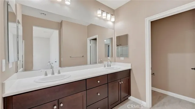 a bathroom with double vanity sinks and a mirror