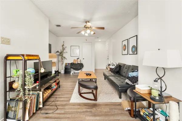 a living room with furniture a flat screen tv and a floor to ceiling window