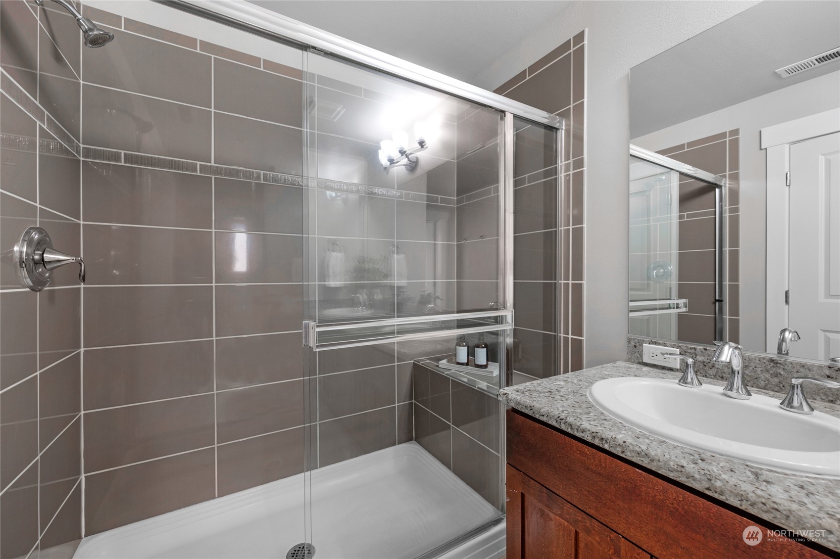 2115 201st Place Southeast, Unit D2 Bothell, WA 98012 - Photo 24 of 31 a bathroom with a granite countertop sink a mirror and a shower