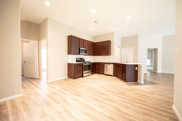 a large kitchen with stainless steel appliances kitchen island granite countertop a sink and cabinets