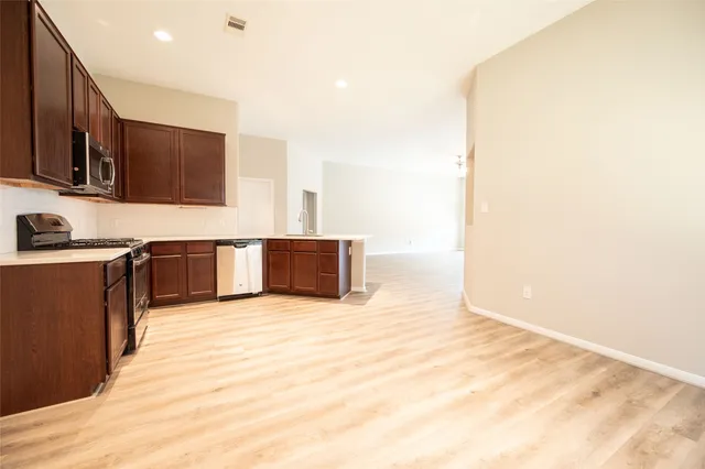 a large kitchen with stainless steel appliances granite countertop a sink and cabinets