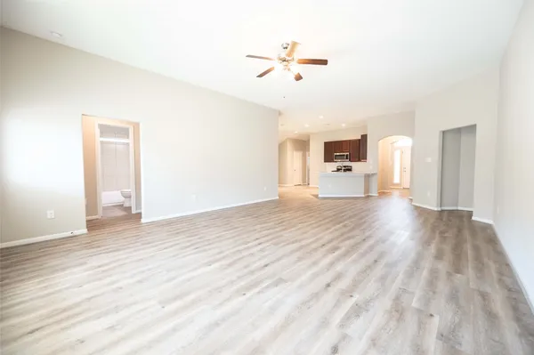 a view of a room with wooden floor and ceiling fan