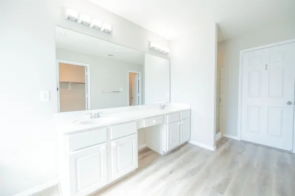 a spacious bathroom with a double vanity sink and mirror