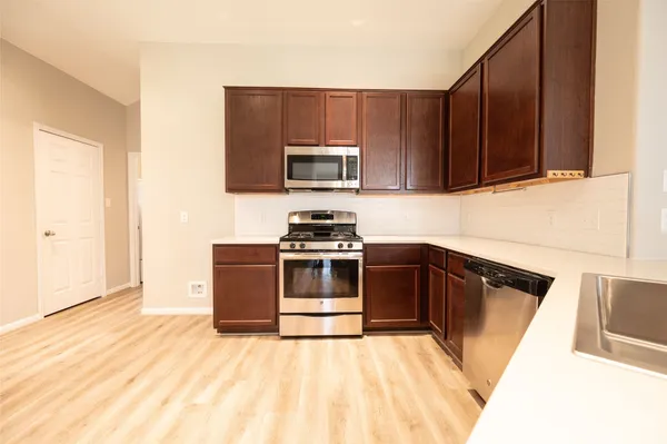 a kitchen with granite countertop wooden cabinets and stainless steel appliances