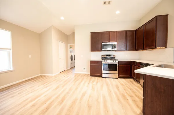 a kitchen with stainless steel appliances granite countertop a stove a sink and a refrigerator