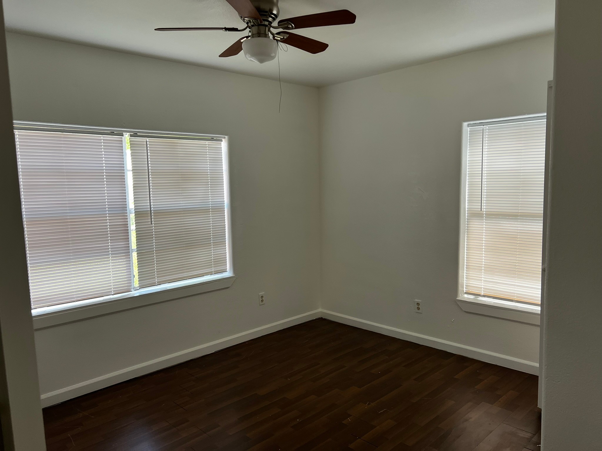 4817 12th Street, Unit A Bacliff, TX 77518 - Photo 4 of 6 an empty room with wooden floor fan and windows