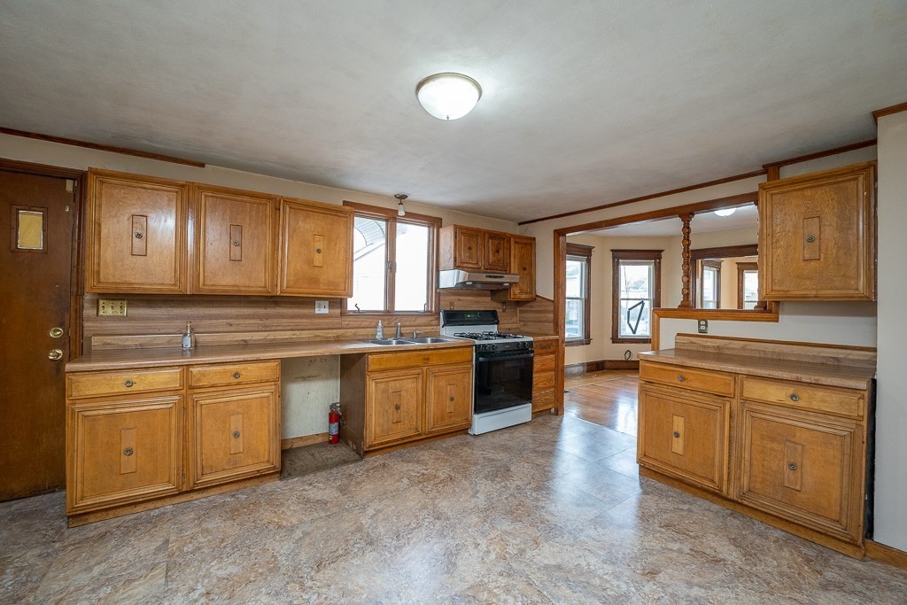 215 White Street Springfield, MA 01108 - Photo 5 of 33 a large kitchen with granite countertop a stove top oven a sink a dining table and chairs