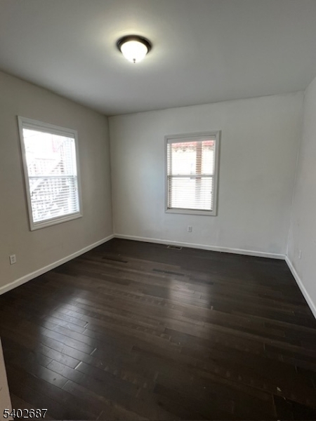 428 Brook Street, Unit 1 Linden, NJ 07036 - Photo 11 of 14 an empty room with wooden floor and windows