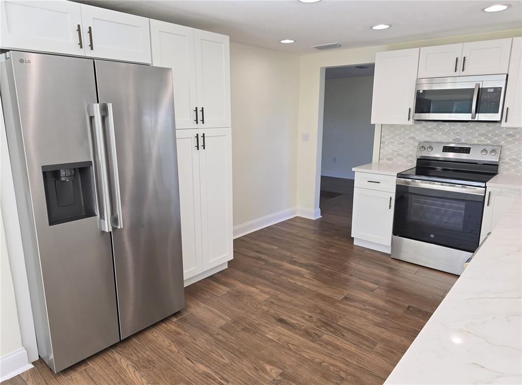 3604 Delta Place Holiday, FL 34691 - Photo 11 of 41 a kitchen with stainless steel appliances and wooden floor