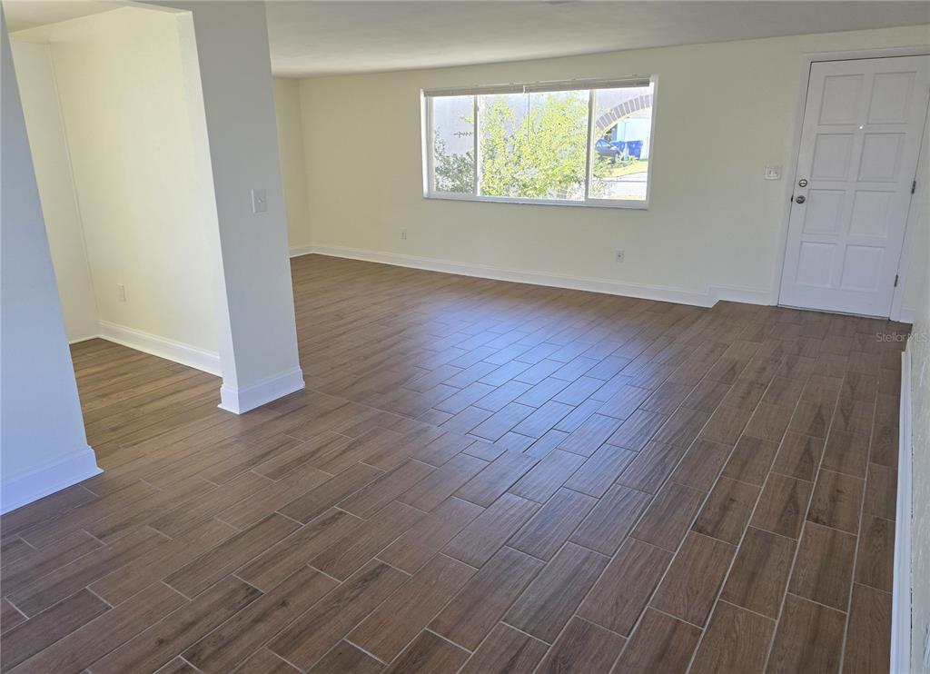 3604 Delta Place Holiday, FL 34691 - Photo 26 of 41 an empty room with wooden floor cabinet and windows