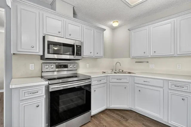 a kitchen with white cabinets and stainless steel appliances