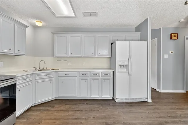 a kitchen with stainless steel appliances granite countertop a refrigerator sink and cabinets
