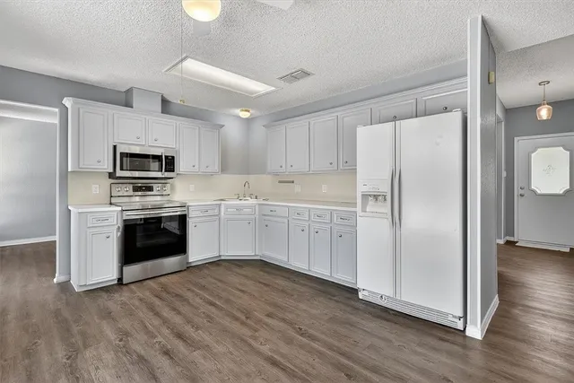 a kitchen with stainless steel appliances a refrigerator sink and microwave