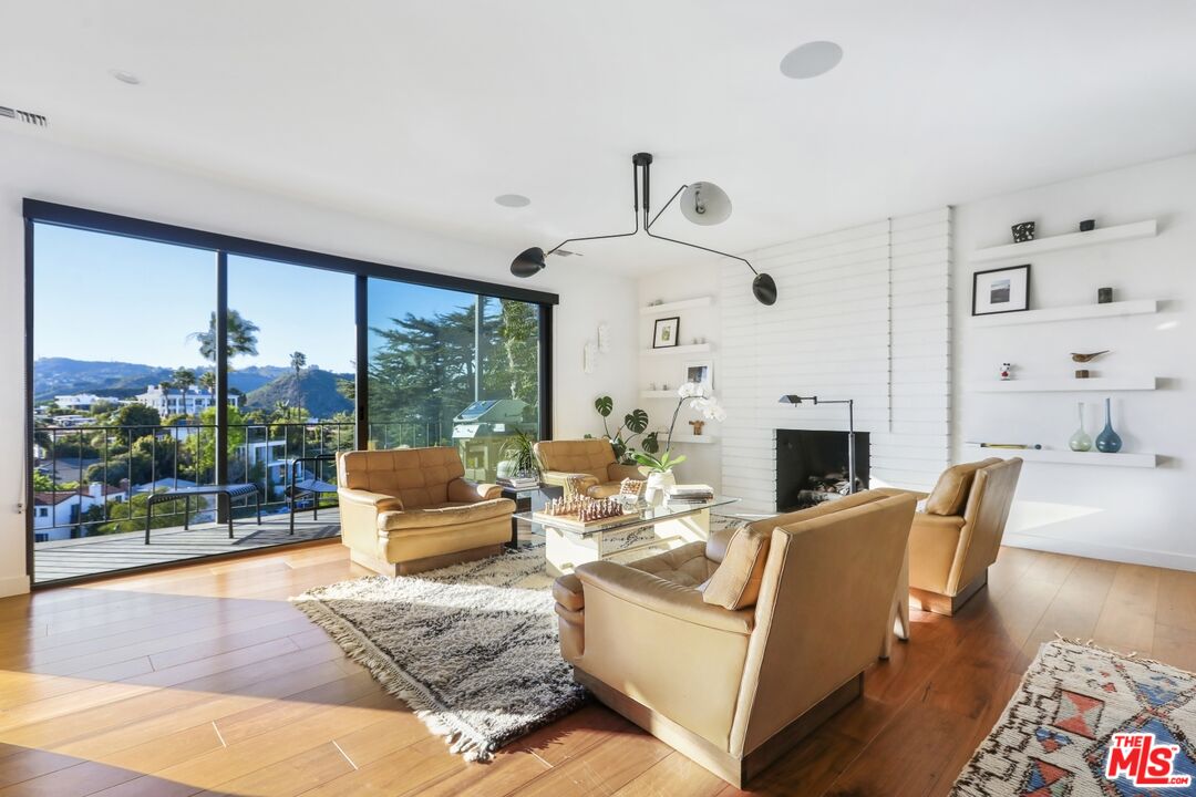 a living room with furniture fireplace and a large window