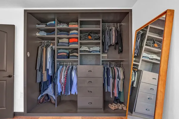 a view of walk in closet with clothes and shoes