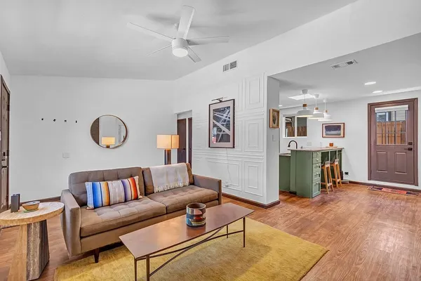 a living room with furniture kitchen view and a window