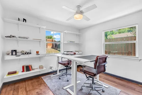 a view of a workspace with furniture and a window