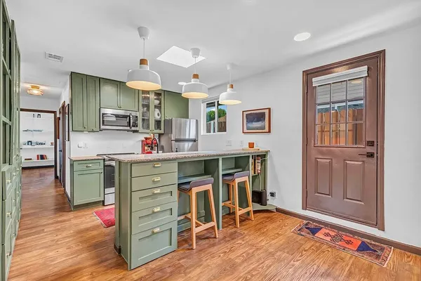 a kitchen view with granite countertop a refrigerator and cabinets