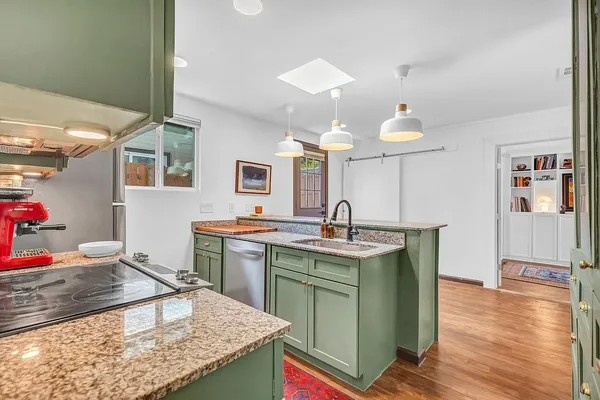 a kitchen with kitchen island a sink stove and wooden cabinets