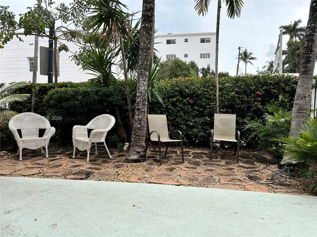 a couple of chairs sitting in a backyard with large trees