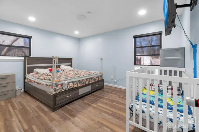 a bedroom with bed and a baby crib