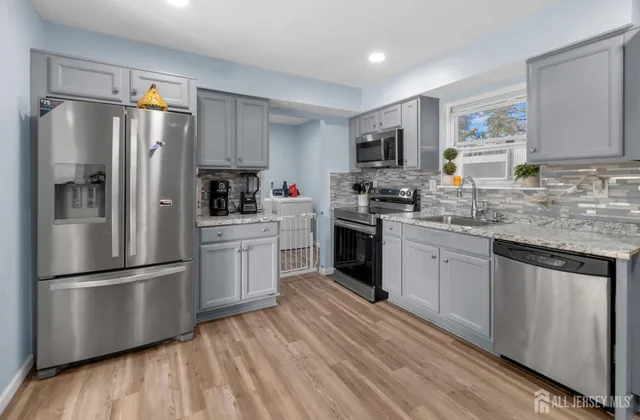 a kitchen with stainless steel appliances a refrigerator sink and microwave