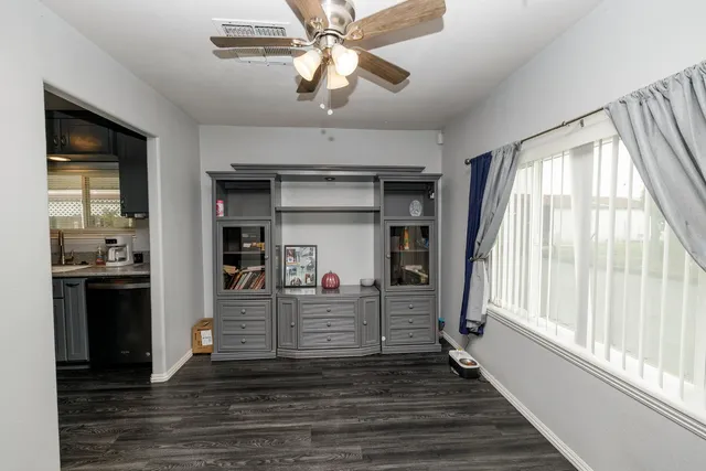 a view of a hallway with wooden floor and cabinet