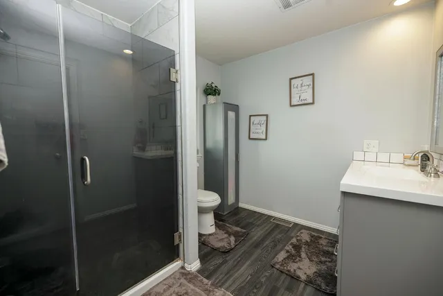 a bathroom with a granite countertop sink toilet and shower