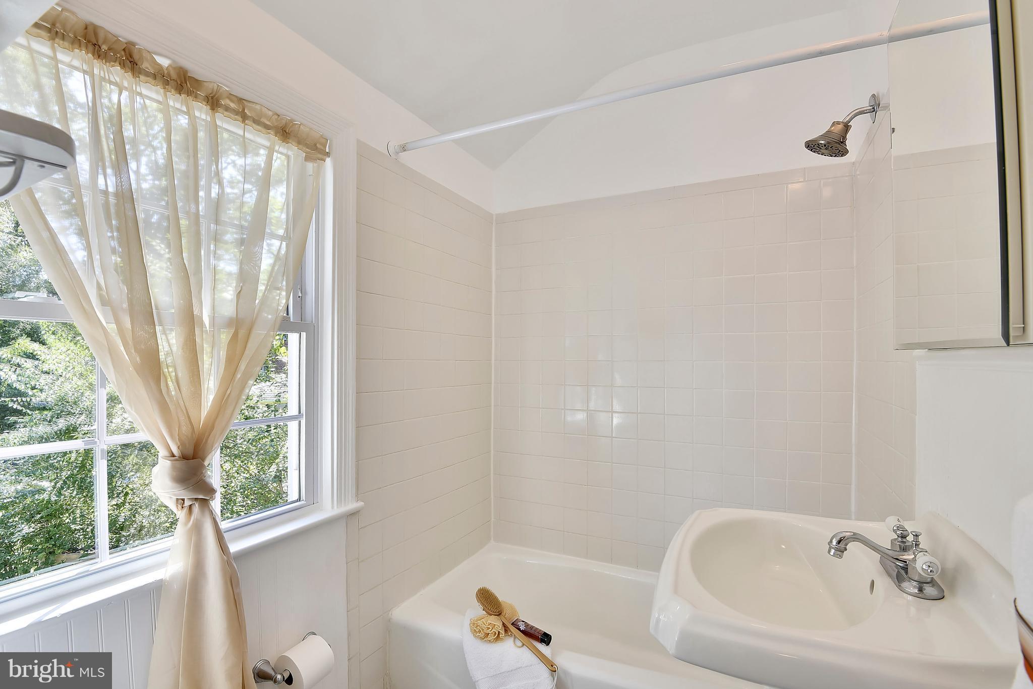 10001 Raynor Road Silver Spring, MD 20901 - Photo 13 of 30 a bathroom with a bathtub a sink and a window