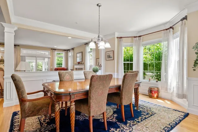 a dining room with furniture a chandelier and wooden floor