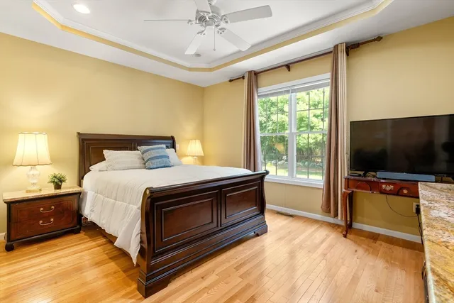 a bedroom with a bed and a flat tv screen on dresser