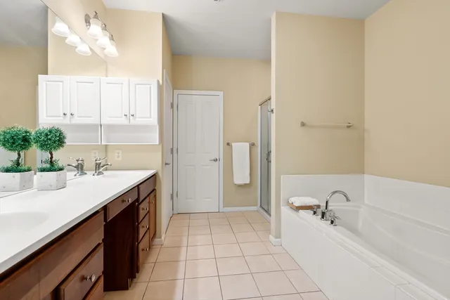 a spacious bathroom with a tub sink and mirror