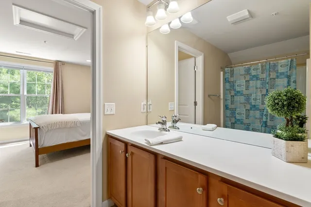 a en suite bathroom with a double vanity sink a large mirror and a bathtub
