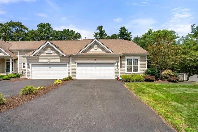 a front view of a house with a garden and yard