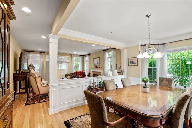 a view of a dining room and livingroom with furniture wooden floor a chandelier