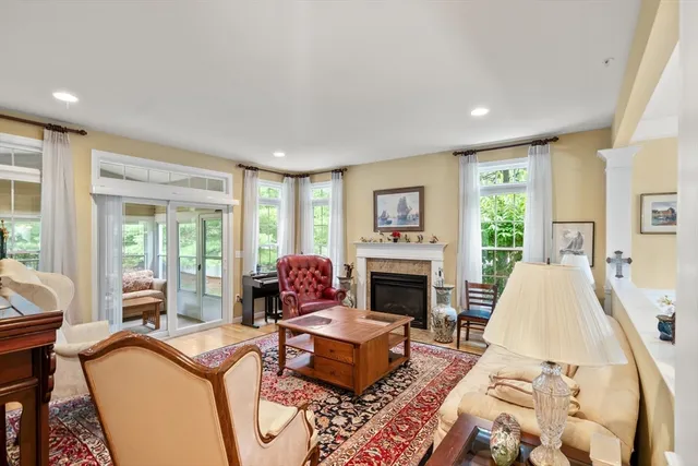 a living room with furniture fireplace and a large window