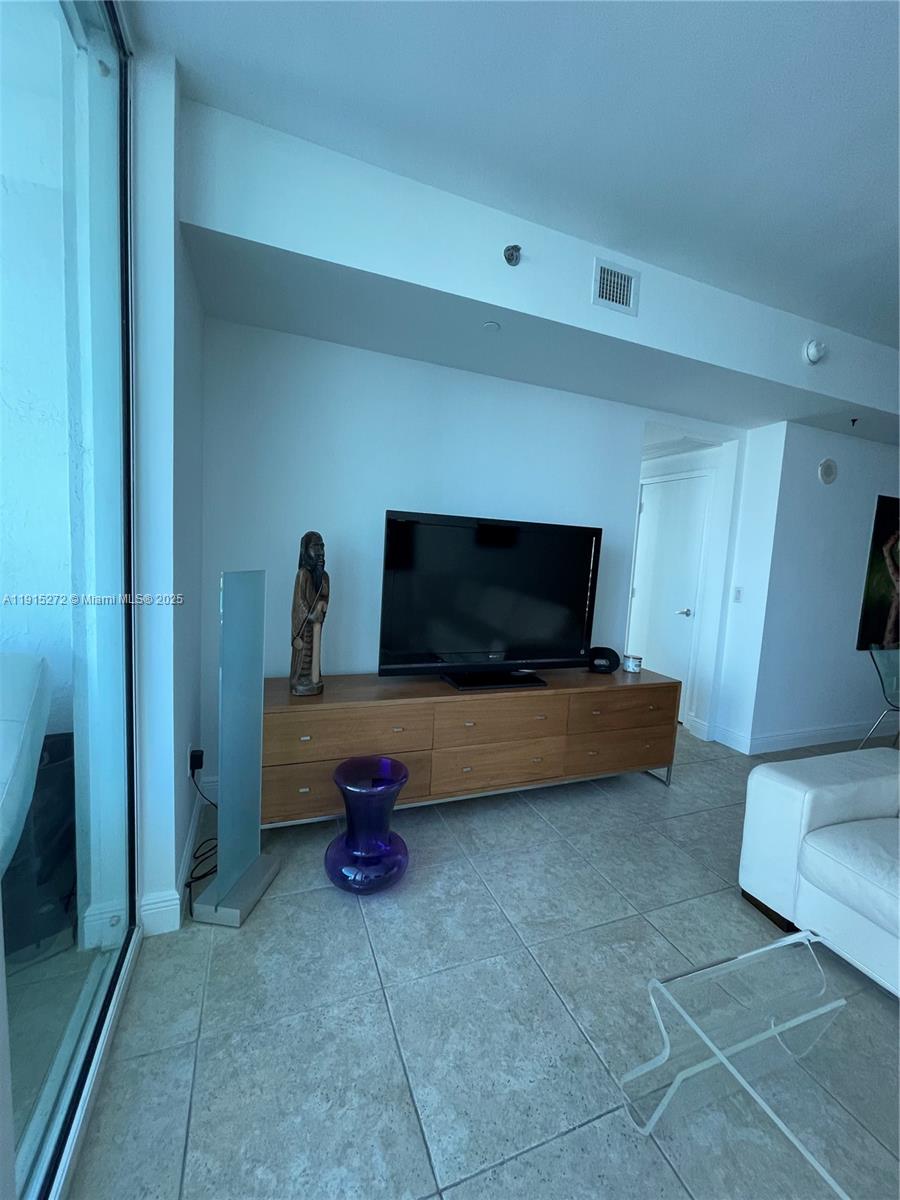 951 Brickell Avenue, Unit 1700 Miami, FL 33131 - Photo 12 of 17 a living room with furniture and a flat screen tv