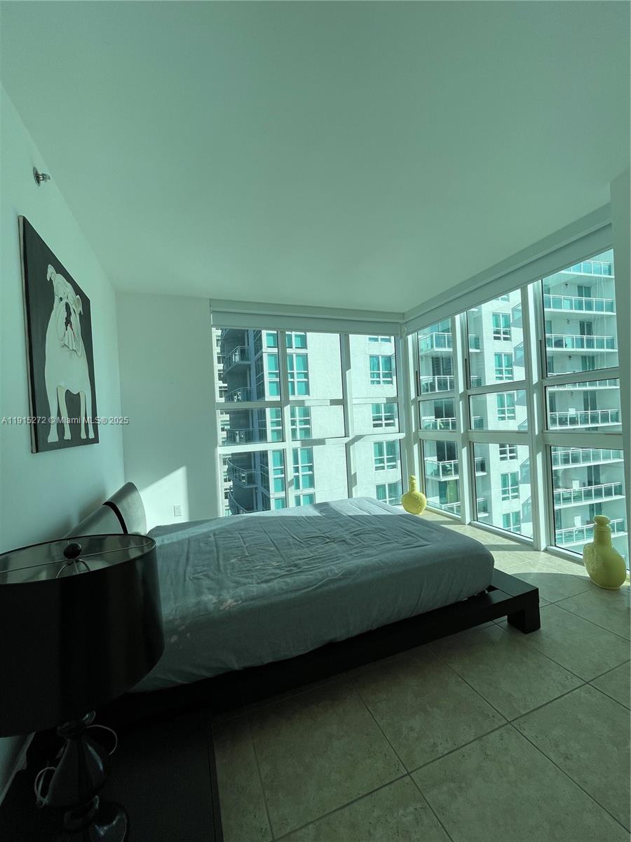 951 Brickell Avenue, Unit 1700 Miami, FL 33131 - Photo 13 of 17 a bedroom with a bed and wooden floor