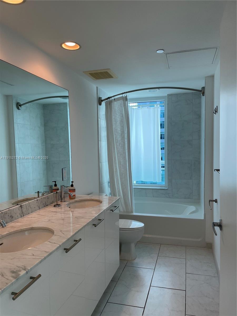 951 Brickell Avenue, Unit 1700 Miami, FL 33131 - Photo 16 of 17 a bathroom with a sink a toilet and shower