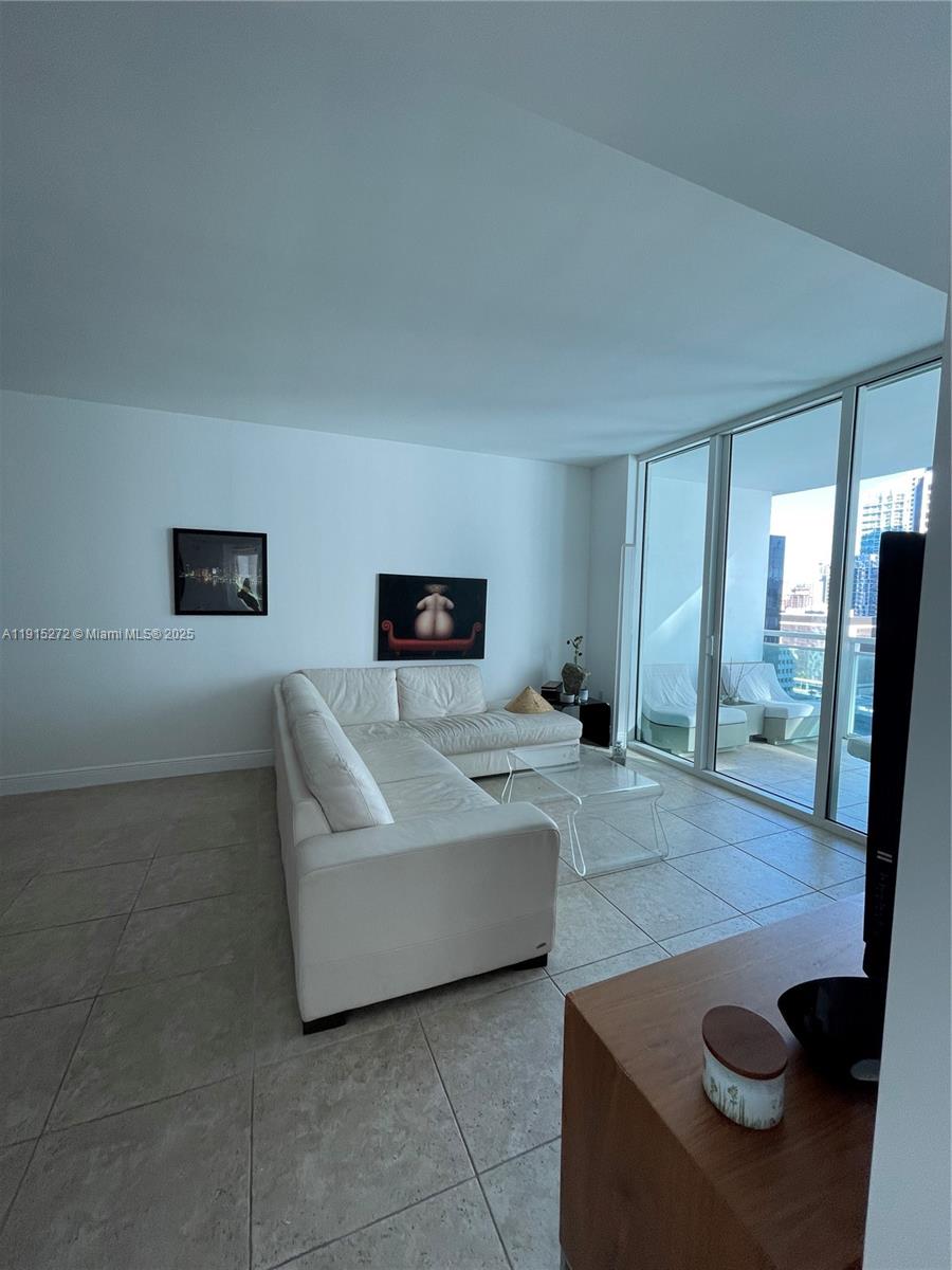 951 Brickell Avenue, Unit 1700 Miami, FL 33131 - Photo 2 of 17 a living room with furniture and a flat screen tv