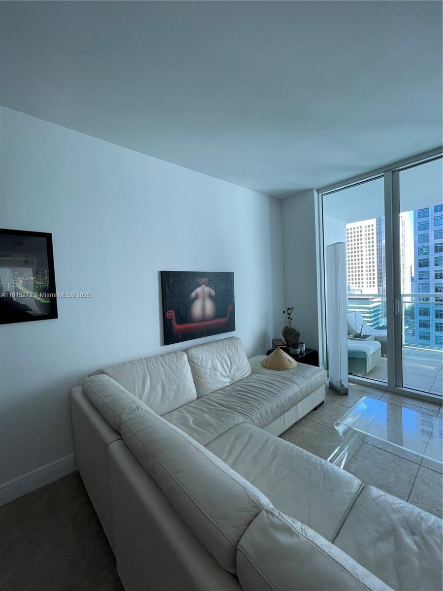951 Brickell Avenue, Unit 1700 Miami, FL 33131 - Photo 4 of 17 a living room with a couch and a flat screen tv