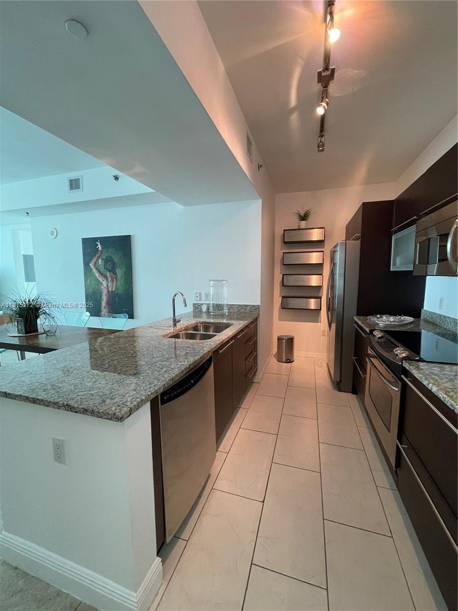 951 Brickell Avenue, Unit 1700 Miami, FL 33131 - Photo 5 of 17 a kitchen with stainless steel appliances granite countertop a sink and cabinets