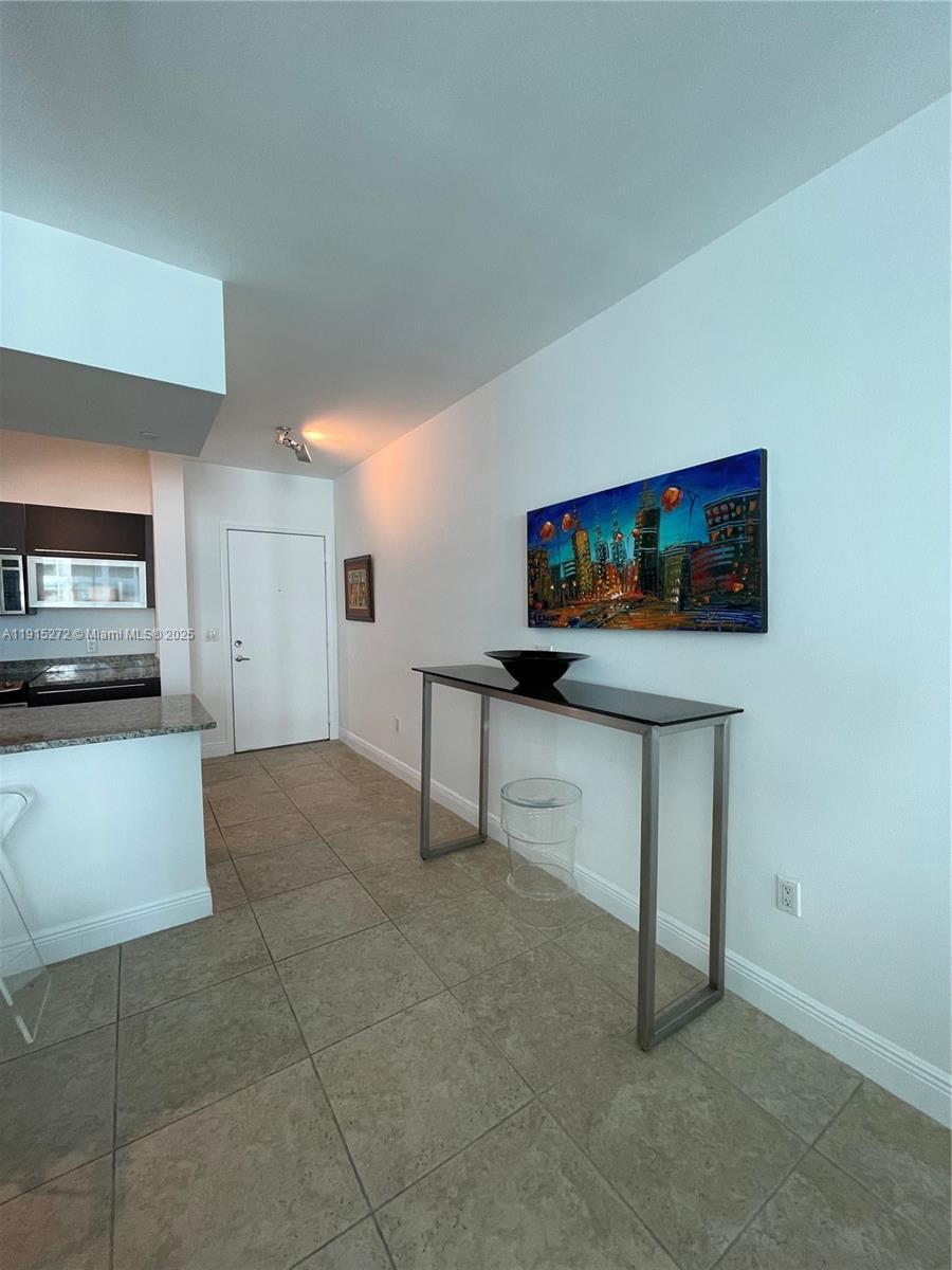 951 Brickell Avenue, Unit 1700 Miami, FL 33131 - Photo 7 of 17 a hallway view with furniture and a flat screen tv