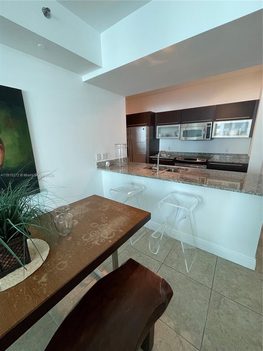 951 Brickell Avenue, Unit 1700 Miami, FL 33131 - Photo 8 of 17 a kitchen with sink and view of living room