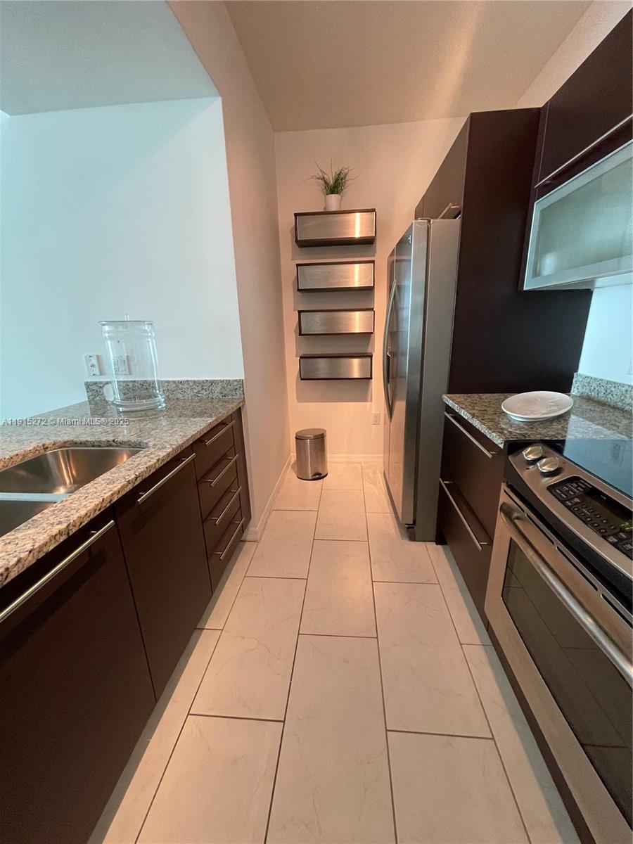 951 Brickell Avenue, Unit 1700 Miami, FL 33131 - Photo 9 of 17 a kitchen with a refrigerator and a sink