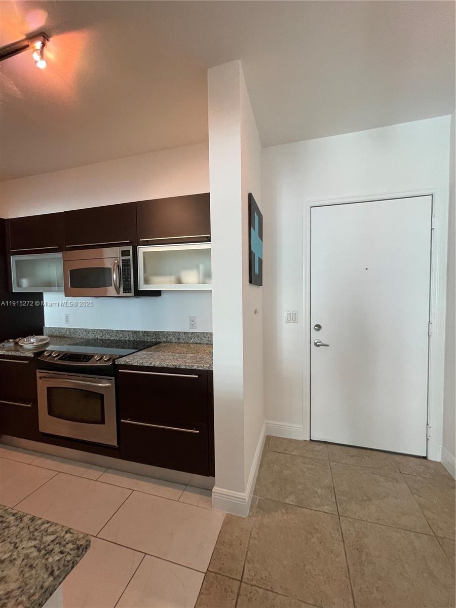 951 Brickell Avenue, Unit 1700 Miami, FL 33131 - Photo 10 of 17 a large kitchen with granite countertop a stove and a refrigerator