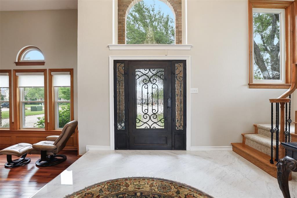 2406 River Road Granbury, TX 76048 - Photo 4 of 40 Ornate iron and glass double entry doors beneath an arched transom window