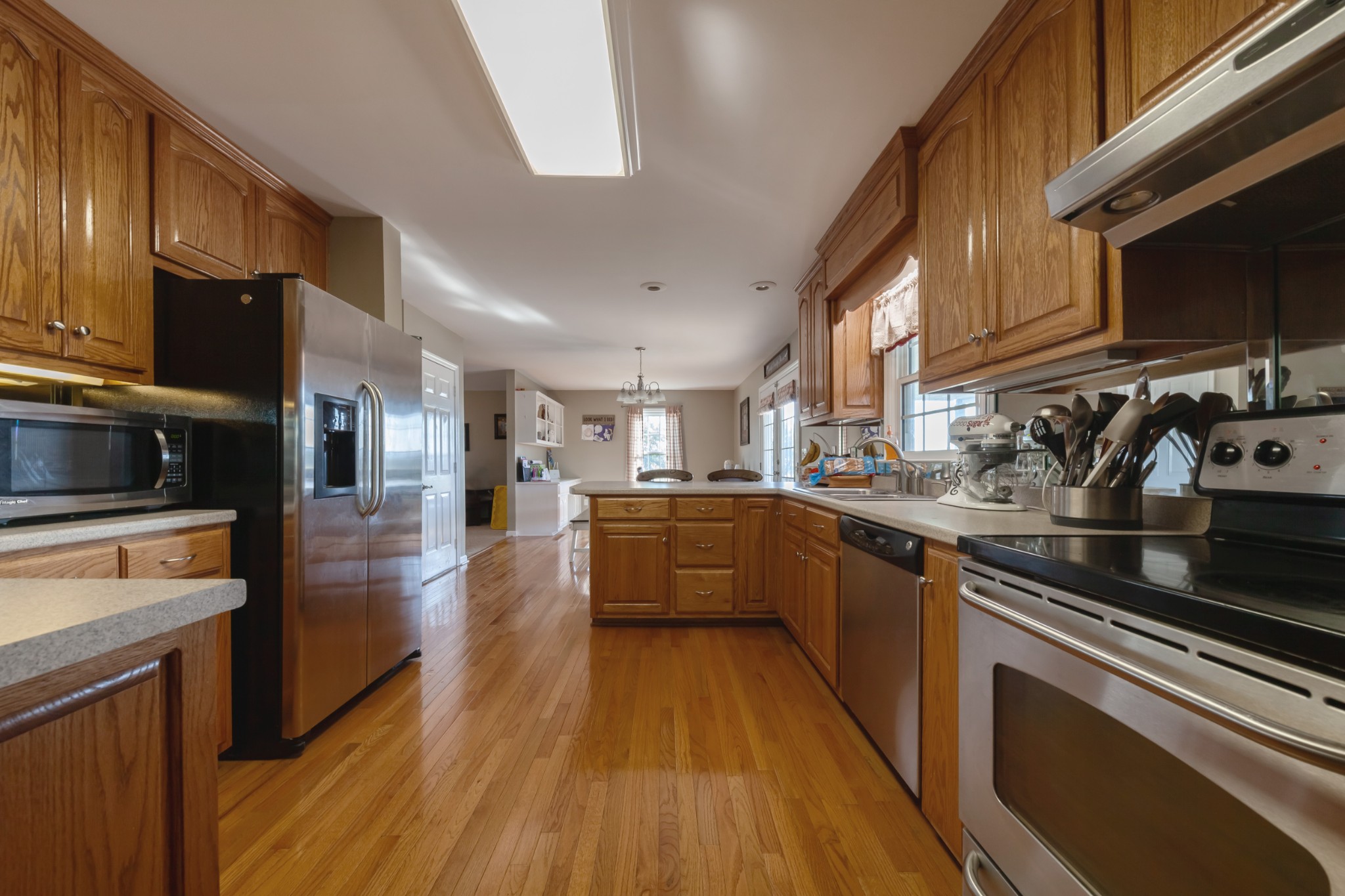 7055 Buford Station Road Lynnville, TN 38472 - Photo 16 of 34 a large kitchen with stainless steel appliances granite countertop a stove a sink dishwasher and a microwave oven with wooden floor