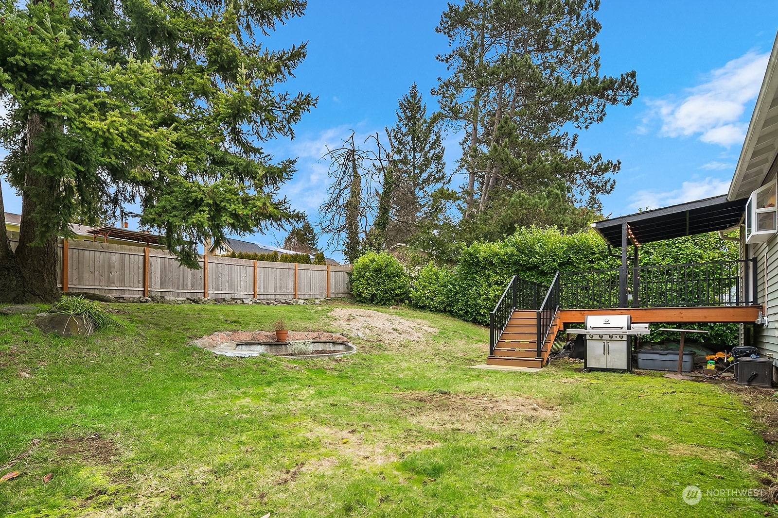 12728 Southeast 163rd Street Renton, WA 98058 - Photo 26 of 40 a backyard of a house with table and chairs plants and large tree