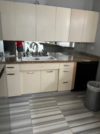 a kitchen with granite countertop a sink and a stove